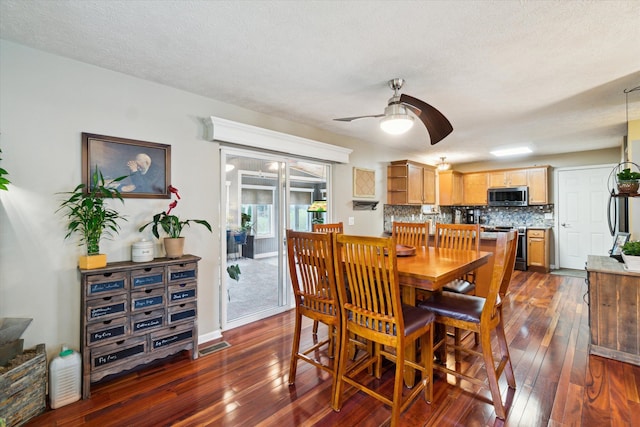 dining room featuring visible vents, a textured ceiling, dark wood-style flooring, and ceiling fan