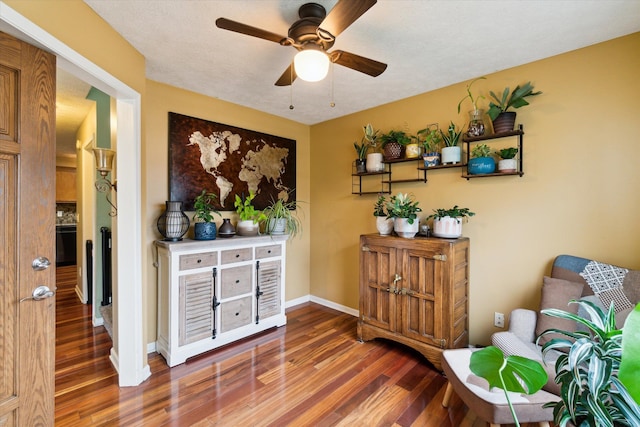sitting room featuring baseboards, ceiling fan, and wood finished floors