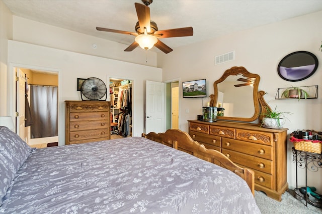 bedroom featuring visible vents, carpet floors, a closet, a spacious closet, and a ceiling fan