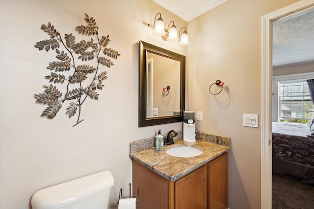 bathroom with vanity, a textured ceiling, and toilet