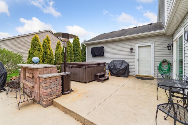 view of patio with a hot tub and a grill