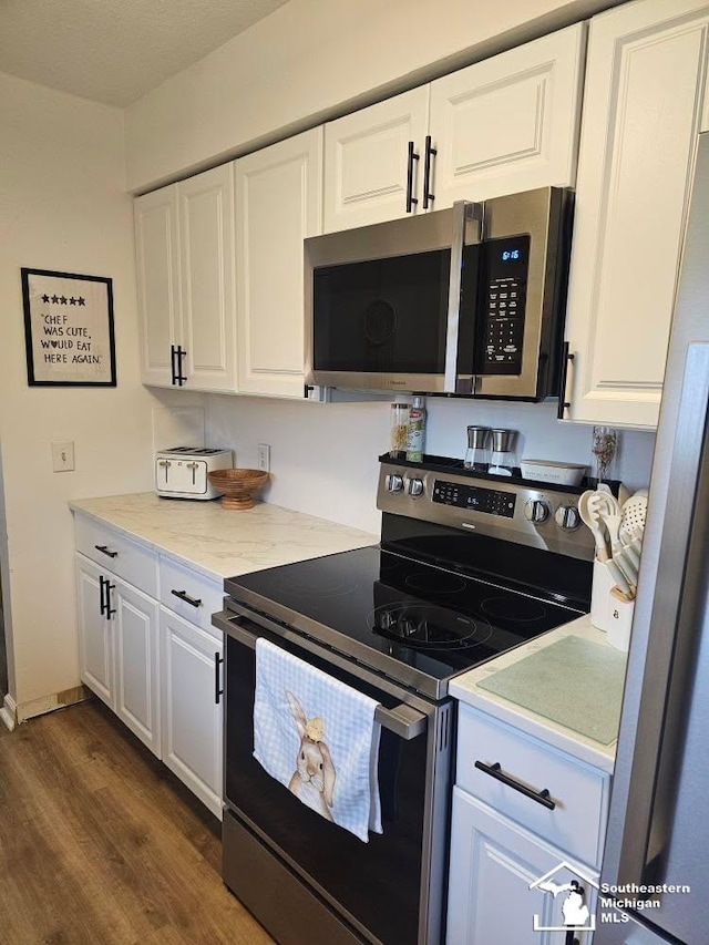 kitchen featuring white cabinets, light countertops, dark wood-style flooring, and stainless steel appliances