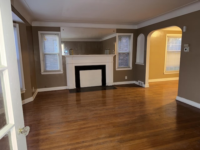 5566 Somerset Ave, Detroit, MI 48224 - unfurnished living room with baseboards, a fireplace with flush hearth, visible vents, arched walkways, and wood finished floors