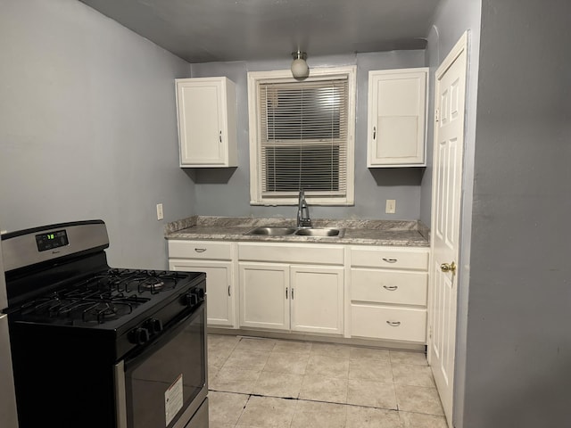 5566 Somerset Ave, Detroit, MI 48224 - kitchen featuring light tile patterned floors, light countertops, white cabinetry, gas range, and a sink
