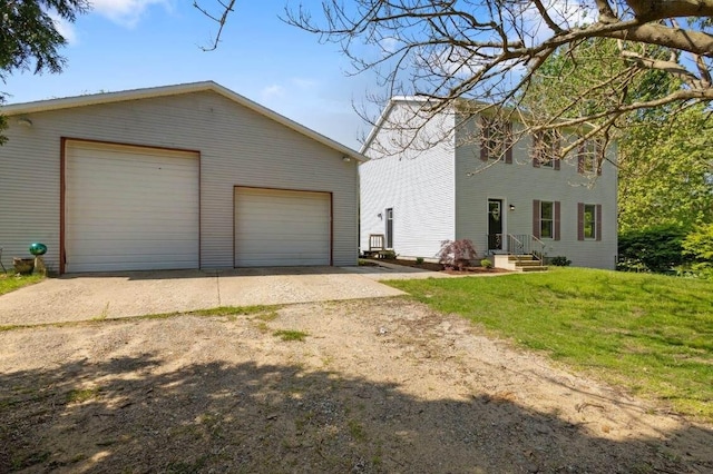 view of side of home with a garage, an outdoor structure, and a yard