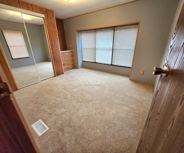unfurnished bedroom with a closet, carpet, and visible vents