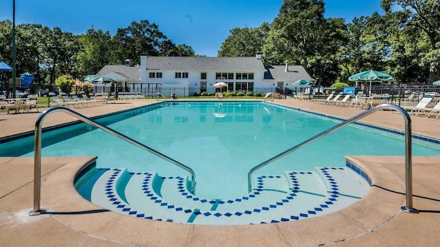community pool featuring a patio area and fence