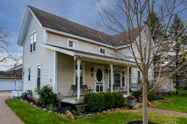 33 N Church St, Ortonville, MI 48462 - view of front of property with an outdoor structure, a porch, a shingled roof, and a garage