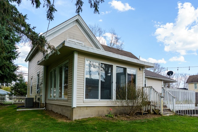 33 N Church St, Ortonville, MI 48462 - view of home's exterior with a lawn, fence, and central air condition unit