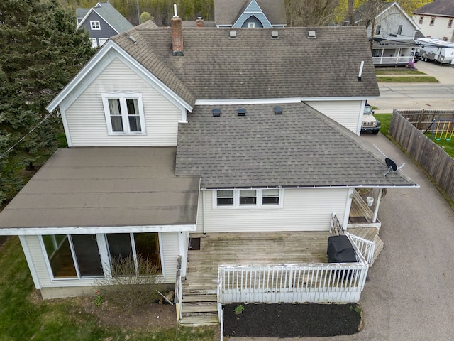 33 N Church St, Ortonville, MI 48462 - rear view of house featuring fence, roof with shingles, a deck, and a chimney