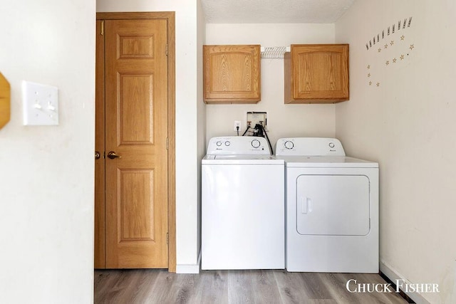 laundry room featuring dark wood finished floors, cabinet space, and independent washer and dryer