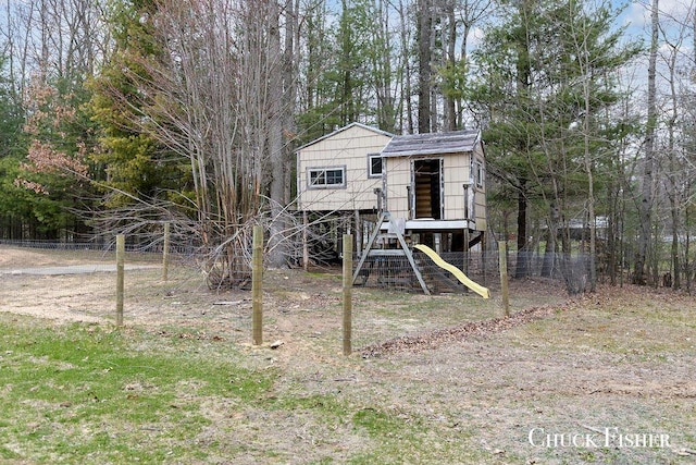 view of outbuilding featuring fence and a playground