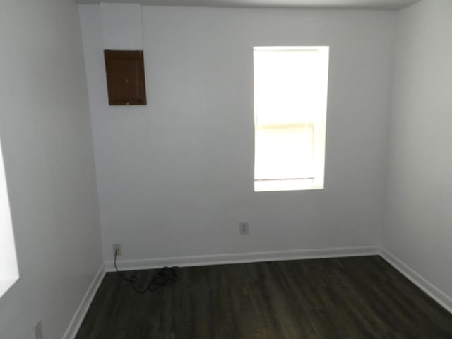 1187 Villa Ct, Benton Harbor, MI 49022 - unfurnished room with baseboards, dark wood-style floors, and electric panel