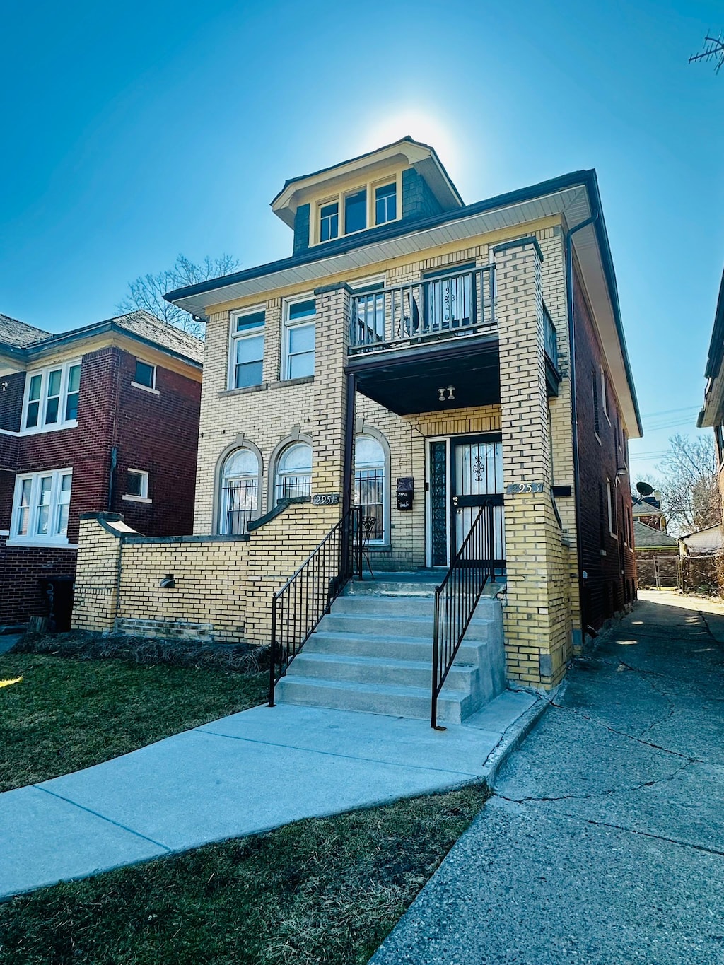 view of front facade featuring brick siding and a balcony