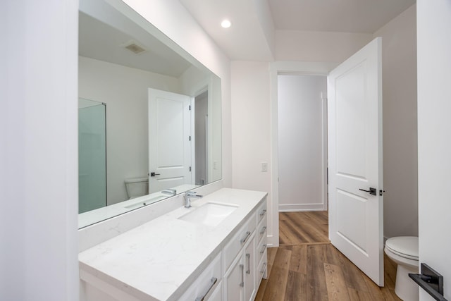 bathroom with visible vents, toilet, recessed lighting, vanity, and wood finished floors