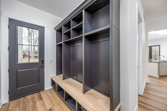 mudroom featuring a sink and light wood finished floors