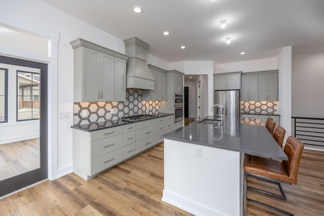 kitchen with tasteful backsplash, a sink, appliances with stainless steel finishes, dark countertops, and gray cabinets