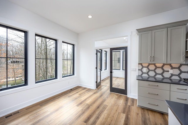 interior space with plenty of natural light, gray cabinetry, visible vents, and dark countertops