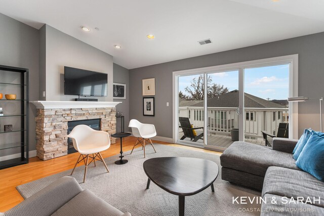201C Outlook Dr Unit 8, Douglas, MI 49406 - living room featuring visible vents, baseboards, a stone fireplace, wood finished floors, and lofted ceiling