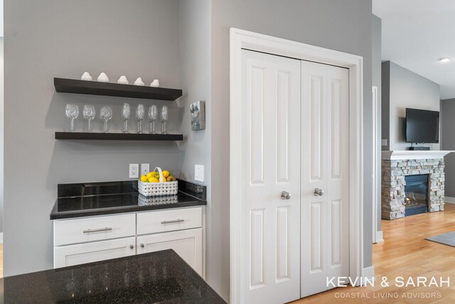 201C Outlook Dr Unit 8, Douglas, MI 49406 - bar featuring light wood-style floors and a stone fireplace