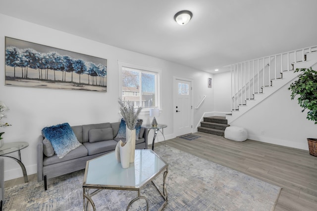 living area with recessed lighting, stairway, baseboards, and wood finished floors