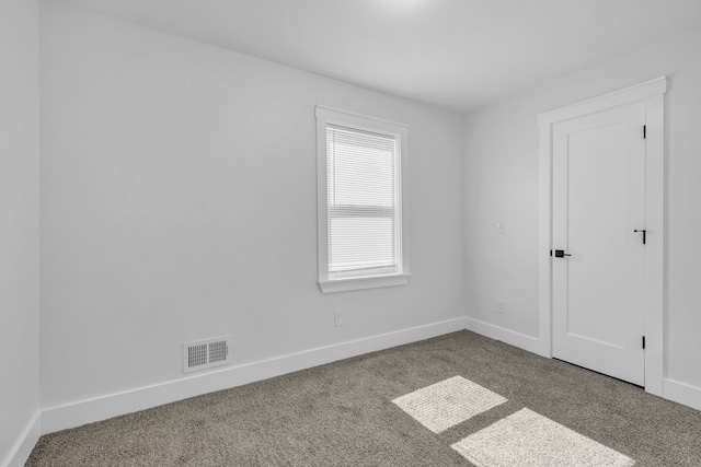empty room with visible vents, baseboards, and carpet flooring