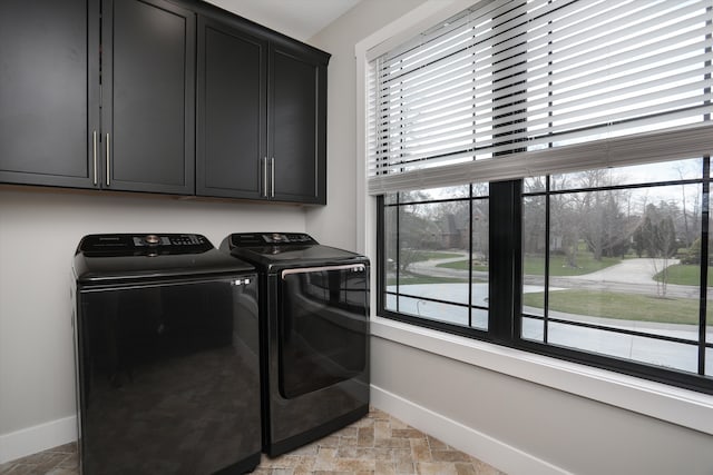 21907 Westcroft Dr, Grosse Ile, MI 48138 - laundry area featuring stone finish floor, baseboards, cabinet space, and washer and clothes dryer