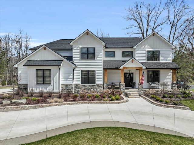 21907 Westcroft Dr, Grosse Ile, MI 48138 - modern farmhouse featuring a porch, roof with shingles, board and batten siding, and stone siding