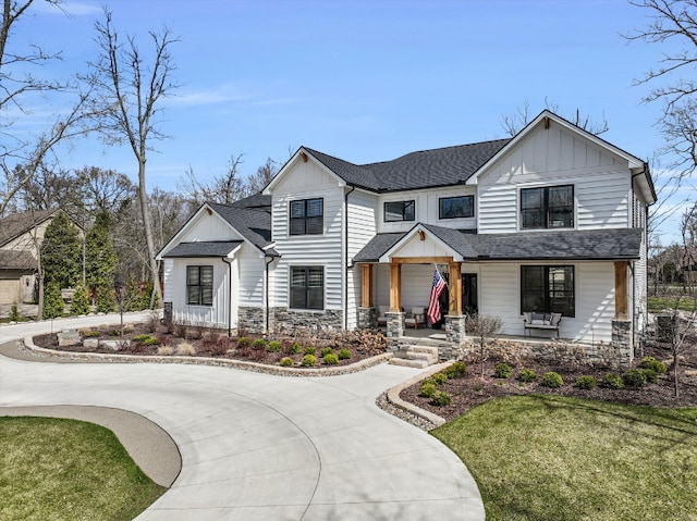 21907 Westcroft Dr, Grosse Ile, MI 48138 - view of front of property featuring a front yard, a shingled roof, a porch, board and batten siding, and curved driveway