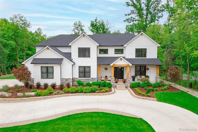 21907 Westcroft Dr, Grosse Ile, MI 48138 - modern inspired farmhouse featuring covered porch, a shingled roof, stone siding, and board and batten siding