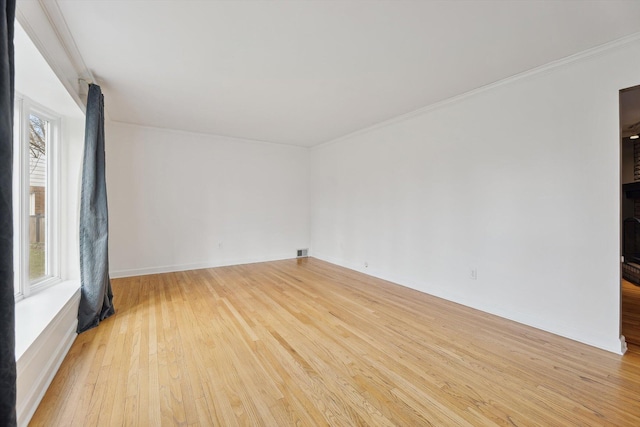 empty room with light wood-type flooring and ornamental molding
