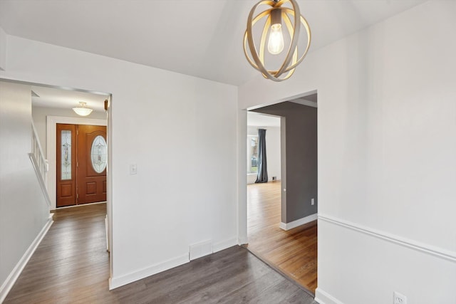 entryway featuring visible vents, baseboards, and wood finished floors