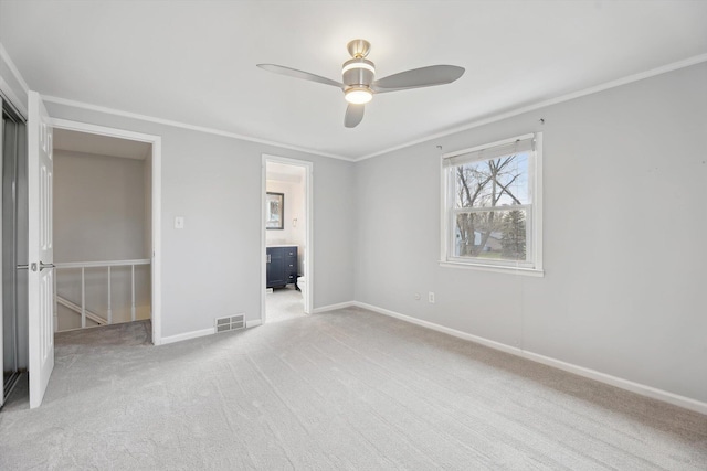 unfurnished bedroom featuring visible vents, baseboards, ornamental molding, a ceiling fan, and light carpet