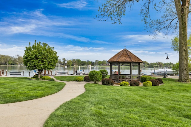 view of property's community featuring a gazebo, a yard, a boat dock, and a water view