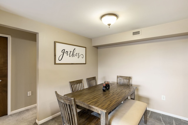 carpeted dining room with baseboards