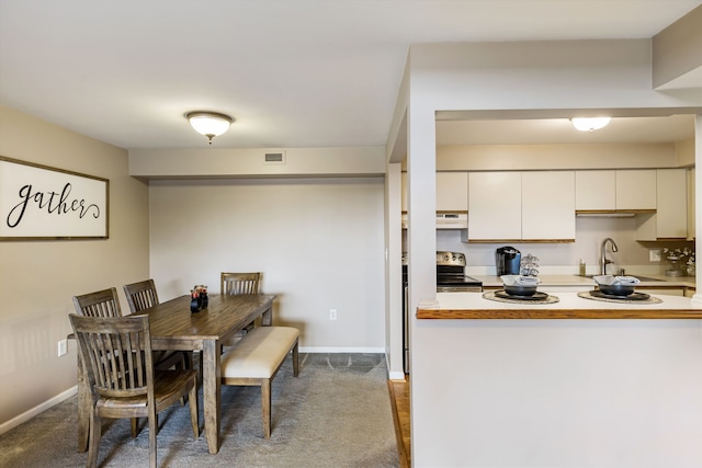 dining room featuring carpet and baseboards