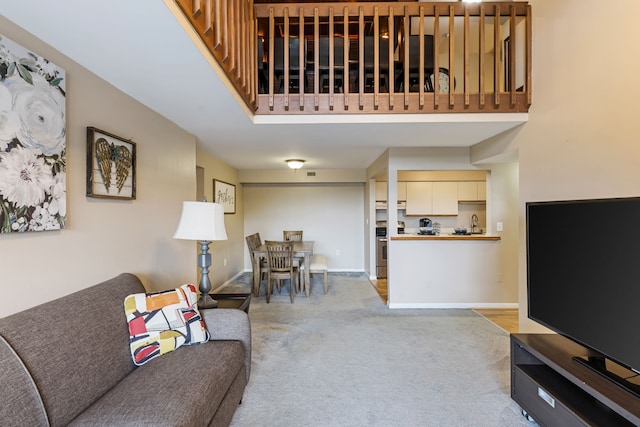 living room with carpet, a high ceiling, and baseboards