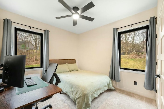 bedroom featuring carpet flooring, multiple windows, baseboards, and ceiling fan