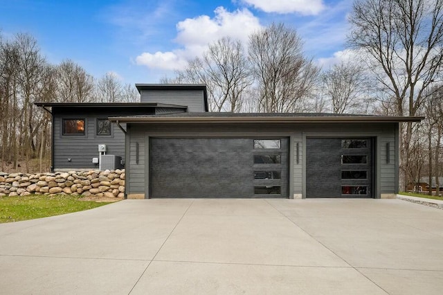 garage featuring concrete driveway and central AC