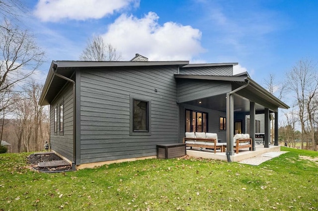 rear view of house featuring a patio area, a lawn, and an outdoor hangout area