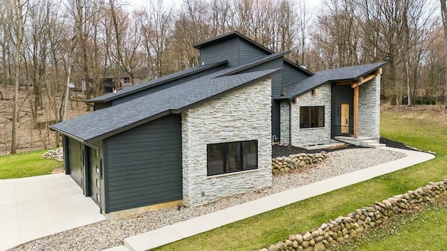 view of home's exterior with stone siding and a shingled roof