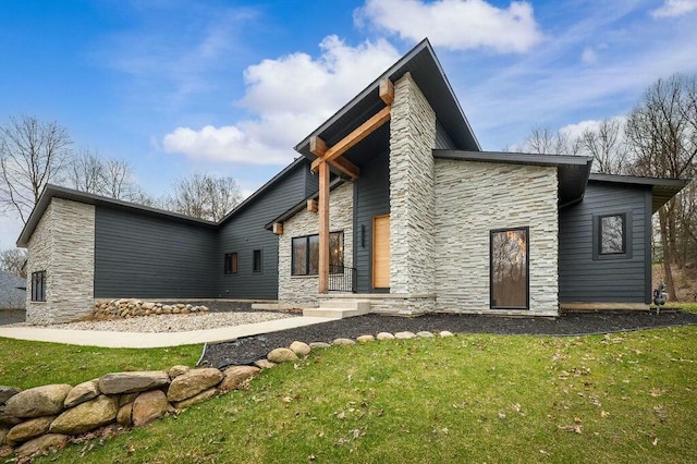rear view of house with a yard and stone siding