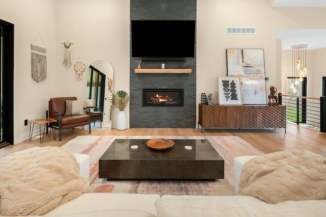 living area featuring wood finished floors, a fireplace, and visible vents