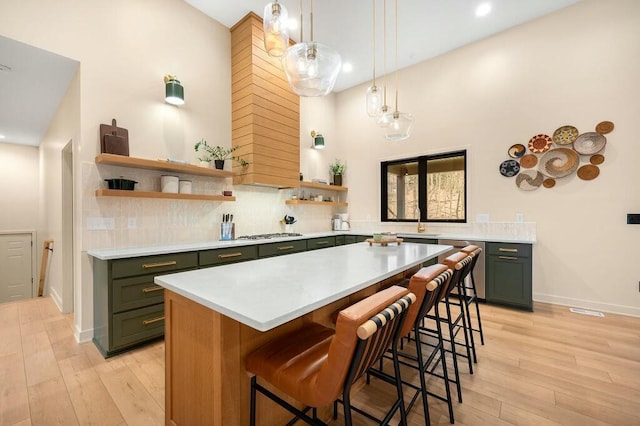 kitchen with green cabinetry, light countertops, backsplash, and open shelves