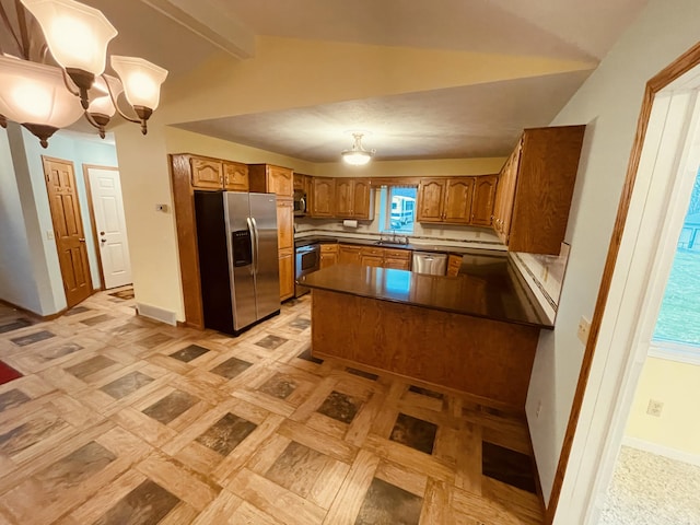 kitchen with stainless steel appliances, dark countertops, lofted ceiling with beams, brown cabinetry, and a notable chandelier