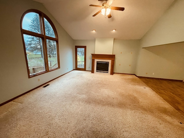 unfurnished living room featuring lofted ceiling, a ceiling fan, visible vents, and baseboards