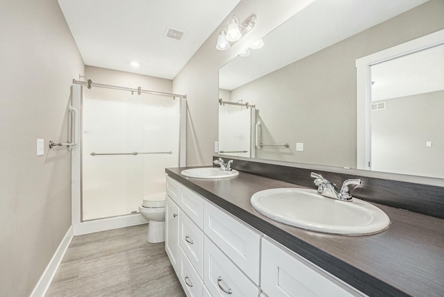 full bath with toilet, a sink, a shower stall, and visible vents