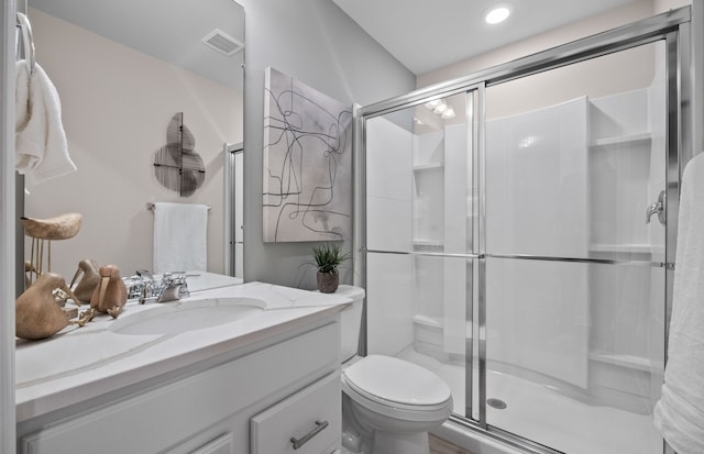 full bath with a shower stall, vanity, visible vents, and toilet