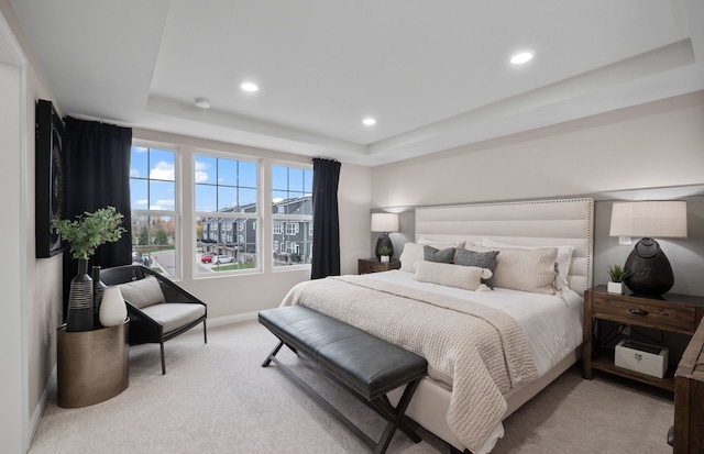 bedroom featuring a tray ceiling, light colored carpet, baseboards, and recessed lighting