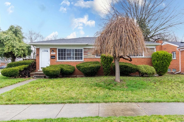 view of front facade with a front yard and brick siding